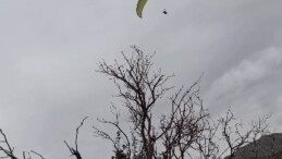 Gönülleri ısıtan davet: Yamaç paraşütçüsü işçilerin çay davetine kayıtsız kalmadı  (Fotoğraflı)  Fevzi Demircan MERSİN (İHA) – Mersin’de fidan dikimi yapan orman işçileri, yemek molası sırasında uçuş yapan yamaç paraşütçüsüne seslenerek çaya davet etti. Daveti karşılıksız bırakmayan paraşütçü iniş yaparak işçilerin yanına giderken ortaya çıkan samimi ve gülümseten anlar cep telefonu kamerasına saniye saniye yansıdı. Olay, Silifke ilçesine bağlı Yeşilovacık Işıklı mevkiinde meydana geldi. Ormanda fidan dikimi yapan işçiler, yemek molasında oldukları sırada üzerlerinden uçuş yapan yamaç paraşütçüsünü fark etti. Paraşütçünün kendilerine yakın mesafeden geçtiğini gören işçiler, seslenerek ‘gel çay içelim’ diyerek davette bulundu. Yapılan davete kayıtsız kalmayan yamaç paraşütçüsü Osman Doğan, işçilere havadan seslenerek ‘geliyorum’ diye yanıt verdi. Uygun bir noktaya iniş yapan Doğan, orman işçilerinin yanına giderek çay içti. Yaşanan bu samimi anlar, orman işçilerinin cep telefonu kamerasıyla kaydedilirken, görüntüler izleyenleri gülümsetti.  “Gel çay içelim diye seslendiler, ben de geliyorum dedim” Helix Paragliding Spor Kulübü yamaç paraşütçüsü Osman Doğan, uçuşun son bölümünde iniş planlaması yaptığı sırada aşağıda orman işçilerinin yemek molasında olduğunu ifade etti. Doğan, “Tam inişi planlarken aşağıdan bir seslenme oldu. ‘Gel çay içelim’ diye bağırdılar. Aslında yönüm orası değildi ama böyle bir daveti geri çevirmek istemedim. Havadan ‘geliyorum’ diye seslendim ve bulundukları bölgeye indim” diye konuştu. İndikten sonra oldukça sıcak bir ortamla karşılaştığını ifade eden Doğan, “Çok hoşgörülü insanlardı. Hava da oldukça soğuktu, çay gerçekten çok iyi geldi. Bir süre sonra kulübümüzden başka arkadaşlarımız da yanımıza geldi. Hep birlikte çay içtik, ardından onlar işlerine devam etti” ifadelerini kullandı.  “Bu sporu tanıtmak istiyoruz” Yaşanan durumun kendisi için de sürpriz olduğunu belirten Doğan, “Genelde indiğimiz yerlerde çocuklar daha çok ilgi gösterir ama bu kez çok samimi bir davet vardı. Yüksekte olmama rağmen seslerini bana duyurmayı başardılar. Yamaç paraşütü ülkemizde henüz çok yaygın bir spor değil. İnsanlar merak ediyor” dedi. Türkiye’nin farklı bölgelerinde de benzer güzel yaklaşımlarla karşılaştıklarını dile getiren Doğan, “Bazen hava şartları nedeniyle planlanmamış yerlere inmek zorunda kalıyoruz. İnsanlar bizi araçlarıyla alıyor, evlerine davet ediyor ya da ekip arkadaşlarımız gelene kadar misafir ediyor. Ülkemizin her yerinde büyük bir saygı ve hoşgörü görüyoruz. Bu konuda herkese teşekkür ediyoruz” diyerek bilgi verdi.