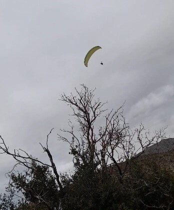 Gönülleri ısıtan davet: Yamaç paraşütçüsü işçilerin çay davetine kayıtsız kalmadı  (Fotoğraflı)  Fevzi Demircan MERSİN (İHA) – Mersin’de fidan dikimi yapan orman işçileri, yemek molası sırasında uçuş yapan yamaç paraşütçüsüne seslenerek çaya davet etti. Daveti karşılıksız bırakmayan paraşütçü iniş yaparak işçilerin yanına giderken ortaya çıkan samimi ve gülümseten anlar cep telefonu kamerasına saniye saniye yansıdı. Olay, Silifke ilçesine bağlı Yeşilovacık Işıklı mevkiinde meydana geldi. Ormanda fidan dikimi yapan işçiler, yemek molasında oldukları sırada üzerlerinden uçuş yapan yamaç paraşütçüsünü fark etti. Paraşütçünün kendilerine yakın mesafeden geçtiğini gören işçiler, seslenerek ‘gel çay içelim’ diyerek davette bulundu. Yapılan davete kayıtsız kalmayan yamaç paraşütçüsü Osman Doğan, işçilere havadan seslenerek ‘geliyorum’ diye yanıt verdi. Uygun bir noktaya iniş yapan Doğan, orman işçilerinin yanına giderek çay içti. Yaşanan bu samimi anlar, orman işçilerinin cep telefonu kamerasıyla kaydedilirken, görüntüler izleyenleri gülümsetti.  “Gel çay içelim diye seslendiler, ben de geliyorum dedim” Helix Paragliding Spor Kulübü yamaç paraşütçüsü Osman Doğan, uçuşun son bölümünde iniş planlaması yaptığı sırada aşağıda orman işçilerinin yemek molasında olduğunu ifade etti. Doğan, “Tam inişi planlarken aşağıdan bir seslenme oldu. ‘Gel çay içelim’ diye bağırdılar. Aslında yönüm orası değildi ama böyle bir daveti geri çevirmek istemedim. Havadan ‘geliyorum’ diye seslendim ve bulundukları bölgeye indim” diye konuştu. İndikten sonra oldukça sıcak bir ortamla karşılaştığını ifade eden Doğan, “Çok hoşgörülü insanlardı. Hava da oldukça soğuktu, çay gerçekten çok iyi geldi. Bir süre sonra kulübümüzden başka arkadaşlarımız da yanımıza geldi. Hep birlikte çay içtik, ardından onlar işlerine devam etti” ifadelerini kullandı.  “Bu sporu tanıtmak istiyoruz” Yaşanan durumun kendisi için de sürpriz olduğunu belirten Doğan, “Genelde indiğimiz yerlerde çocuklar daha çok ilgi gösterir ama bu kez çok samimi bir davet vardı. Yüksekte olmama rağmen seslerini bana duyurmayı başardılar. Yamaç paraşütü ülkemizde henüz çok yaygın bir spor değil. İnsanlar merak ediyor” dedi. Türkiye’nin farklı bölgelerinde de benzer güzel yaklaşımlarla karşılaştıklarını dile getiren Doğan, “Bazen hava şartları nedeniyle planlanmamış yerlere inmek zorunda kalıyoruz. İnsanlar bizi araçlarıyla alıyor, evlerine davet ediyor ya da ekip arkadaşlarımız gelene kadar misafir ediyor. Ülkemizin her yerinde büyük bir saygı ve hoşgörü görüyoruz. Bu konuda herkese teşekkür ediyoruz” diyerek bilgi verdi.